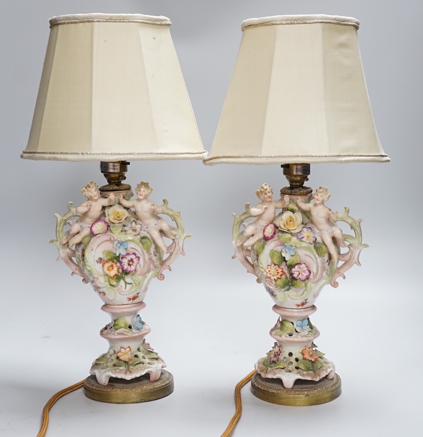 A pair of German porcelain flower encrusted lamps, height 24cm